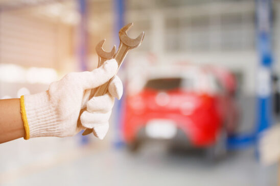 car mechanic holding wrench at the car repair service garage