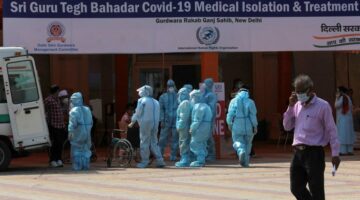 Healthcare workers in personal protective suits wait to receive patients outside a 400 bedded Covid Care facility setup inside Gurudwara Rakab Ganj (Sikh temple), in New Delhi, India on May 10, 2021. India, in the last 24 hours, recorded 3,66,161 fresh Covid-19 cases and 3,754 related deaths.  (Photo by Mayank Makhija/NurPhoto) (Photo by Mayank Makhija / NurPhoto / NurPhoto via AFP)
