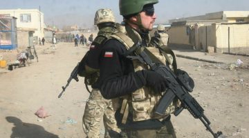 Polish soldiers with the NATO led International Security Assistance Force (ISAF) stand guard near the scene where a Polish armored military vehicle was hit by a road side bomb in Ghazni, west of Kabul, Afghanistan, Wednesday, Dec. 21, 2011. Five Polish soldiers were killed Wednesday when the roadside bomb exploded in eastern Afghanistan, the alliance and a Polish official said. (AP Photo/Rahmatullah Nikzad)