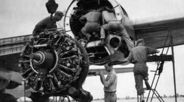 53912 A.C. -  India – Sgt Guy D. Cutter, Detroit, MI, left, and Cpl David Marks, Cincinnati, OH, guide a damaged engine of a Boeing B-29 Superfortress to the ground while three mechanics inspect the engine casing.  (Credit photo to the National Museum of the USAF)
