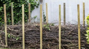 Mittels Gehölszchnitt und sonstigen Gartenabfällen am Ende des Gartens eine Totholz-Hecke bauen. Begrenzung und Stabilisierung durch Holz-Pfähle.