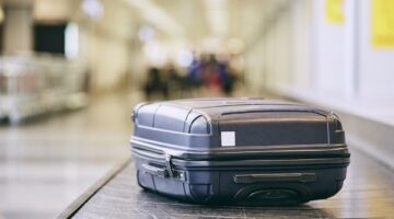 Traveling by airplane. Suitcase on baggage claim in airport terminal.