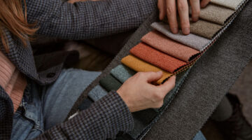 Cropped photo of female and male selecting upholstery material for their couch