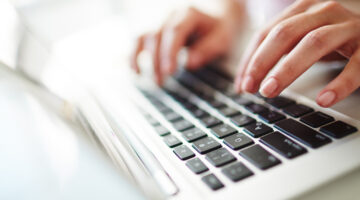 Fingers of female over laptop keypad