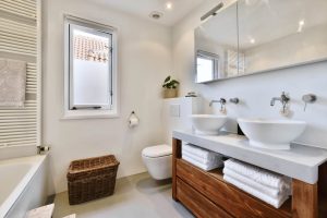 luxury bathroom with two oval sinks and a suspended toilet