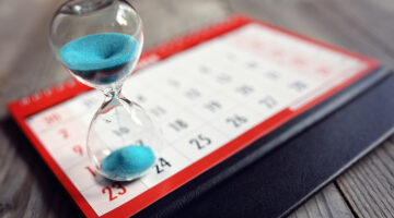 Hour glass on calendar concept for time slipping away for important appointment date, schedule and deadline
