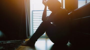 asian,woman,sit,on,the,floor,beside,window,in,dark