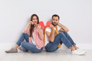 couple with torn paper heart indoors. relationship problems