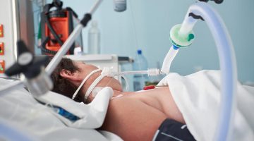 intubated woman with ventilator assisted breathing due to flu or