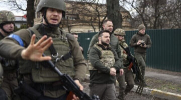 President Volodymyr Zelensky (C) walks in the town of Bucha, just northwest of the Ukrainian capital Kyiv on April 4, 2022. - Ukraine's President Volodymyr Zelensky said on April 3, 2022 the Russian leadership was responsible for civilian killings in Bucha, outside Kyiv, where bodies were found lying in the street after the town was retaken by the Ukrainian army. (Photo by RONALDO SCHEMIDT / AFP)